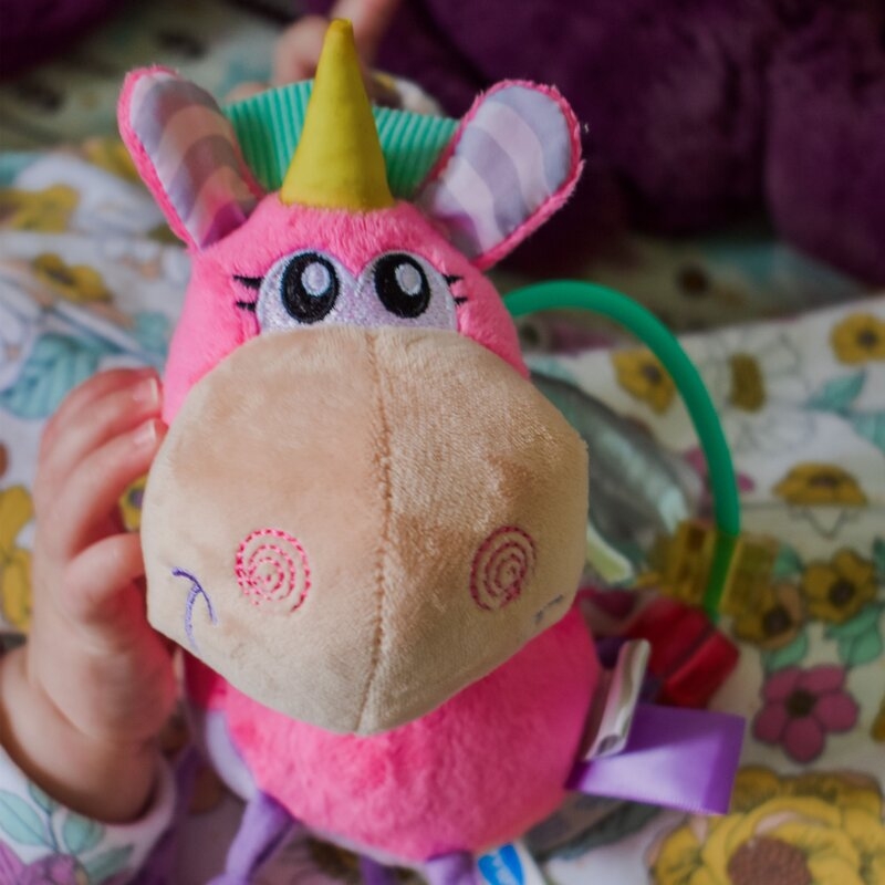 Jucarie din plus, Playgro, Stimuleaza dezvoltarea senzoriala, Utila pentru dentitie, Cu diverse forme si texturi, Cu margele si parti zornaitoare, 0 luni+, Unicorn Activity Rattle